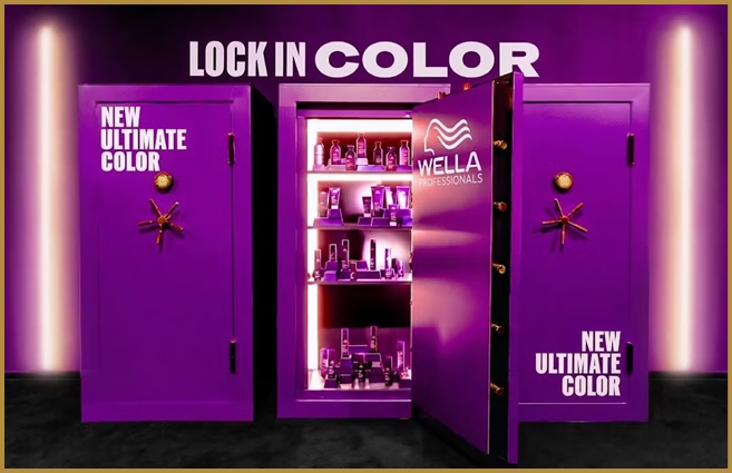 A vibrant purple display features three lockers with the middle one open to reveal shelves stocked with Wella Professionals hair color products and the text “LOCK IN COLOR" and "NEW ULTIMATE COLOR" on the lockers. Description generated by AI